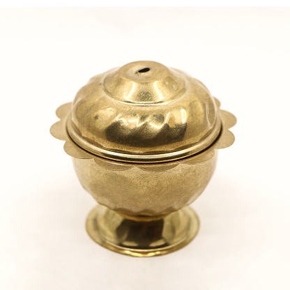 a golden container pot with vintage design and a lid for the box used to store food spice or sindoor powder isolated in a white background