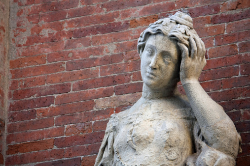 ancient statue with headaches and the brick wall
