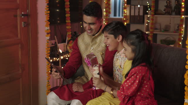 Family video calling over digital tablet at home during Diwali