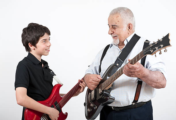 Grandfather and Grandson playing guitars Grandfather and Grandson having fun.  musical equipment photos stock pictures, royalty-free photos & images