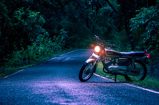 Dandeli, India- 6th december 2022: Yamaha motorcycle parked on the road in the forest at night time