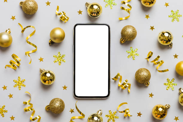 istock Christmas online shopping from home phone with blank white display top view. smart mobile with copy space on colored background with Christmas decorations balls,. Winter holidays sales background 1759142300