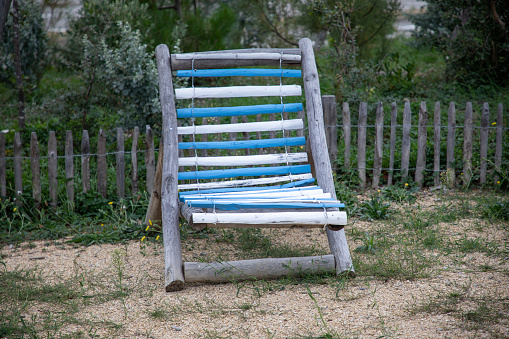 wooden chair chaise longue blue white striped in the garden in summer