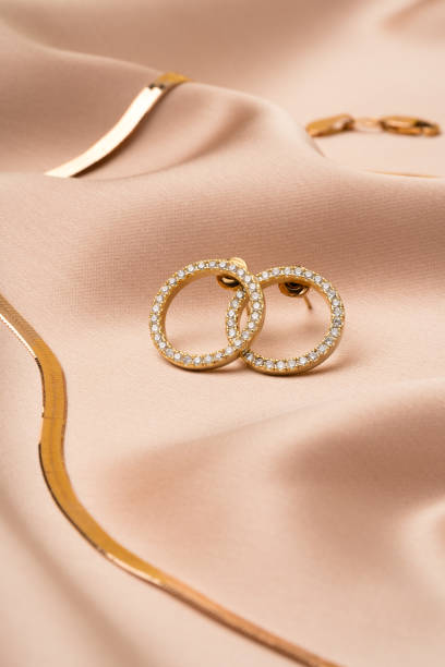 istock Golden chain necklace and earrings on silk background 1759155303