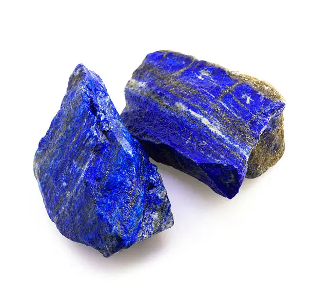 Closeup picture of two hi-quality blue lapis lazuli gemstones isolated on white background.