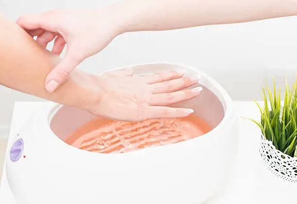 Putting hand in paraffin wax bath