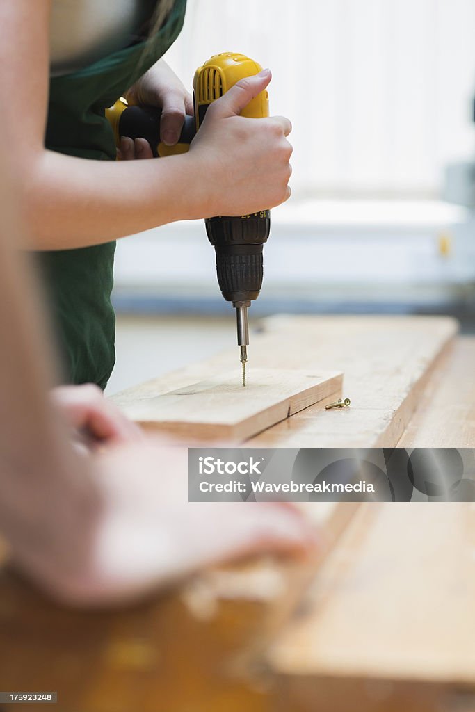 Trou de forage sur une planche en bois sur établi - Photo de Apprenti libre de droits