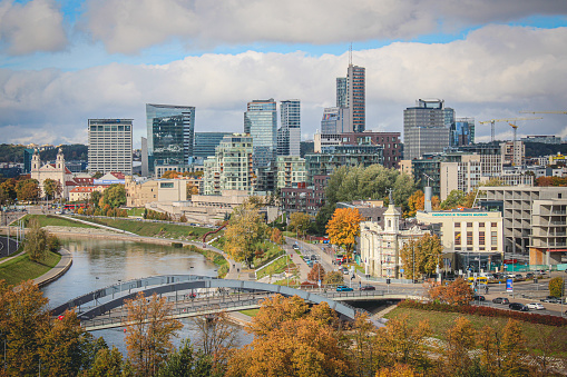 Vilnius, capital of Lithuania, Europe. Aerial view of the city, modern business financial district, modern architecture, buildings and skyscrapers, with Neris river and bridge in autumn