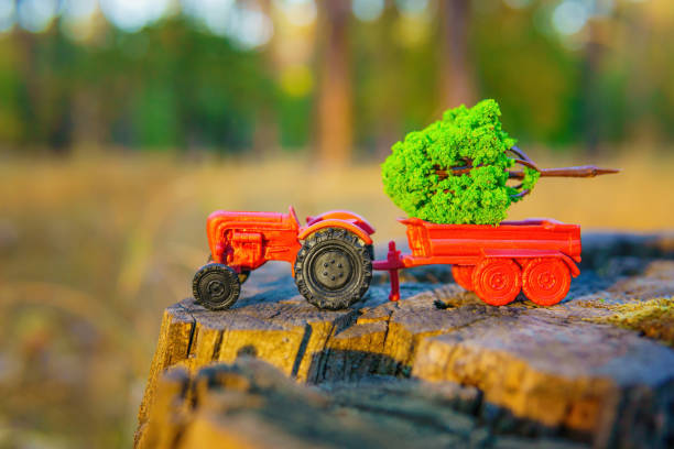 istock Toy Tractor with Miniature Tree on Tree Stump 1759264040