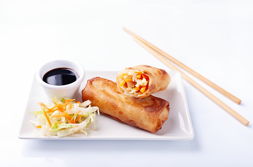 High angle view of spring roll with soy sauce on white background