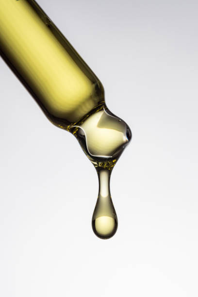 istock Dropper pipette with transparent yellow drops with bubbles on white background. Abstract serum, oil , acid cosmetic product 1759282719
