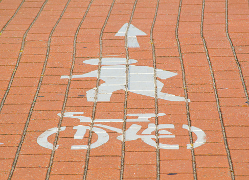 Pedestrian and cycle path sign has painted on the red brick surface,  indicates that the route is to be used by pedal cyclists only where such a route is provided along side a route for other vehicular traffic the cycles must use the cycle route.