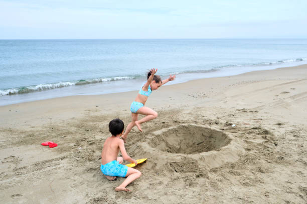 istock Children dig a hole in the sand on the seashore. 1759289246