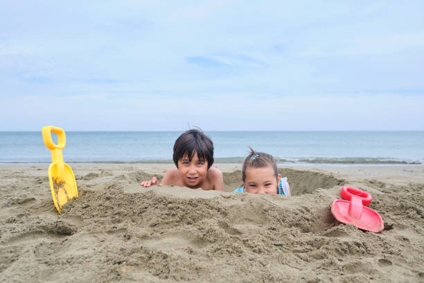 istock Children dig a hole in the sand on the seashore. 1759289774