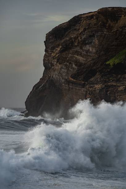 istock a man rides his surfboard near the water's edge 1759292592