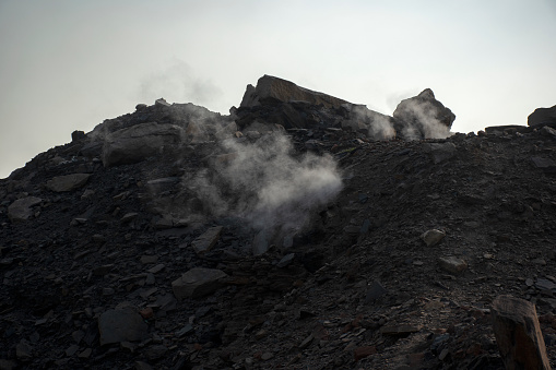 Smoke coming out from a coal mine near Dhanbad city, India.