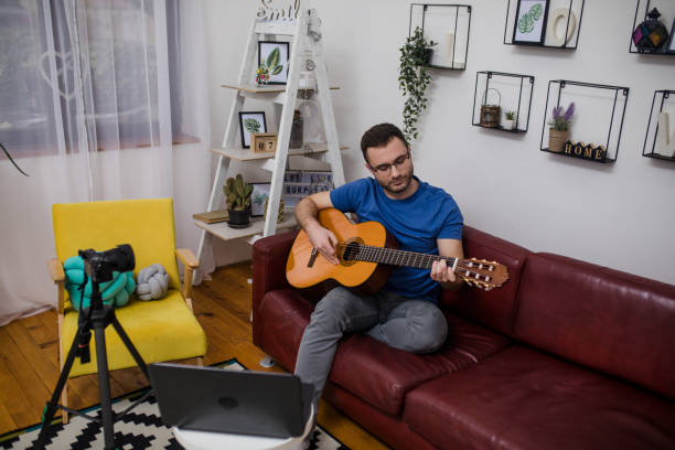 istock Man playing guitar on living room sofa 1759302962