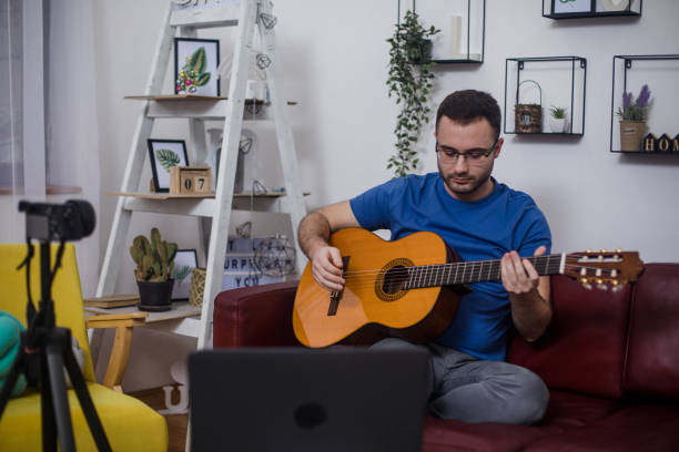 istock Man playing guitar on living room sofa 1759305612