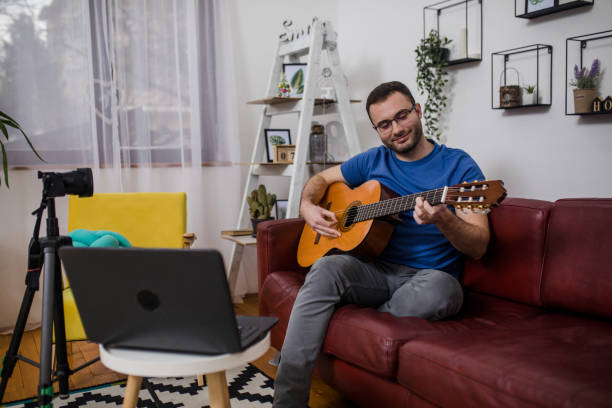 istock Man playing guitar on living room sofa 1759305636