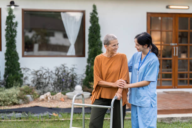 istock Nurse or caregiver help elderly walk by using walker in garden 1759314688