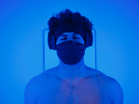 A young adult man in a cryotherapy chamber in a biohacking lab.