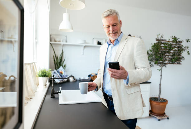 istock Mature businessman using smart phone at home 1759343573