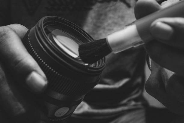 istock Hand Cleaning camera lens with brush, sweeping dust on lens with brush. 1759358772
