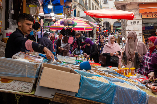 Alger, Algiers, Algeria, 04 19 2023 : crowded street market in the Bab el Oued district of Alger, Algiers, Algeria. Clothes, bags, plastic objects, food for sale.