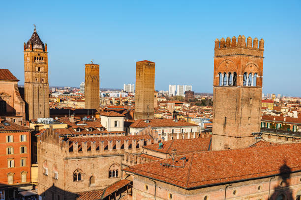 tetti e torri di edifici storici sotto il cielo terso a bologna, italia - bologna italy medieval palace foto e immagini stock