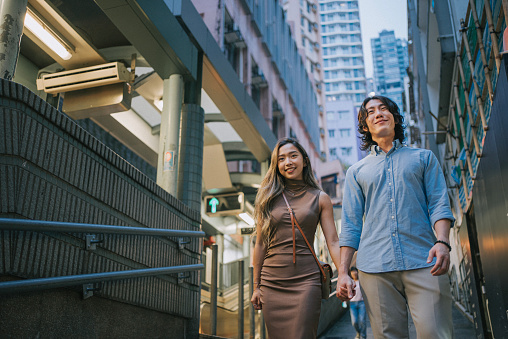 Asian Chinese couple tourist walking in city street in Hong Kong