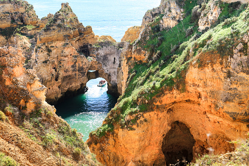 Lagos, Algarve, Portugal- October 20, 2022: Touristic boat full of people visiting coves and limestone formations of Ponta da Piedade in the Algarve, Portugal