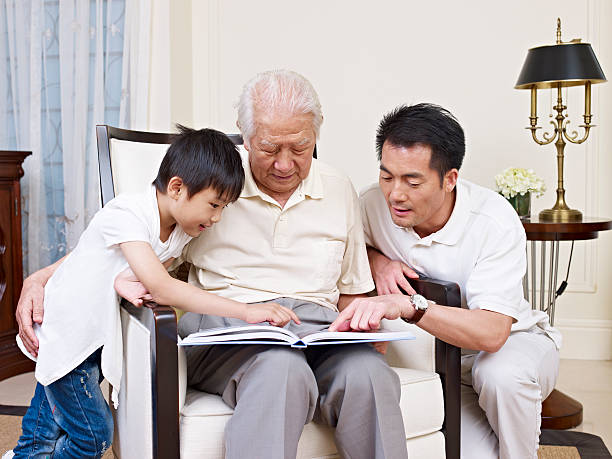 une famille de trois générations - grandparent senior adult child reading photos et images de collection