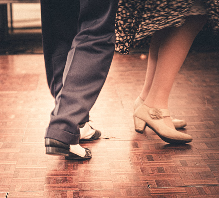 People in 1940s period dress dancing at a vintage re-enactment event.