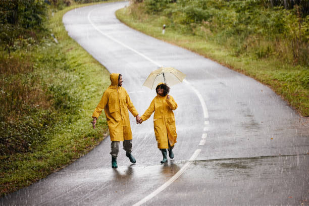 istock Happy black couple walking on empty road during rainy day. 1759432135