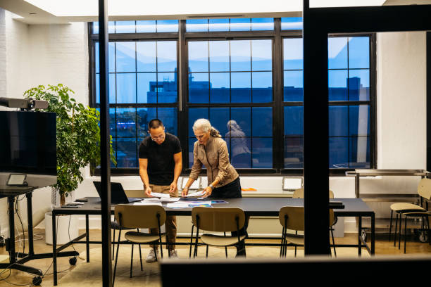 Mature art director and male assistant organizing documents