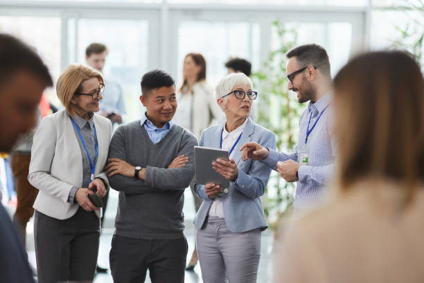 istock Happy business colleagues talking while working on touchpad in a hallway. 1759440161