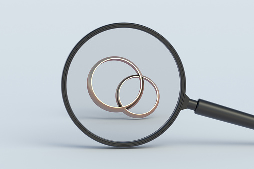 Wedding ring behind magnifying glass. 3d render