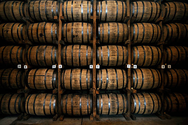 stack of wooden whiskey barrels - ton fotos stockfoto's en -beelden