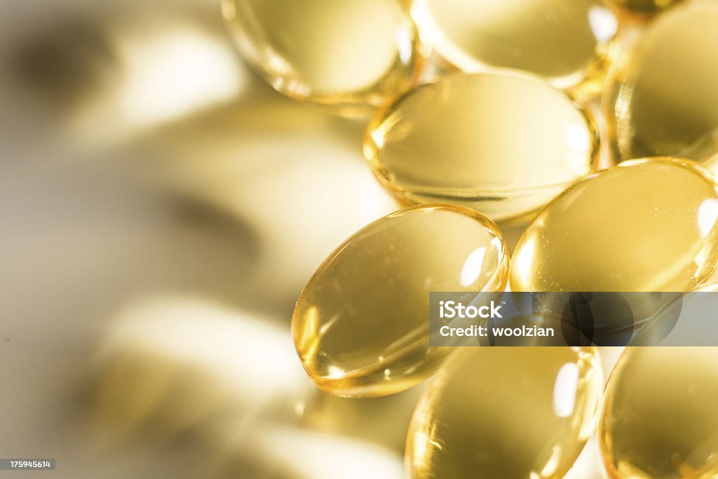 Fish oil tablets macro glowing Omega 3 Fish oil transparent tablets illuminated on white surface Vitamin D Stock Photo