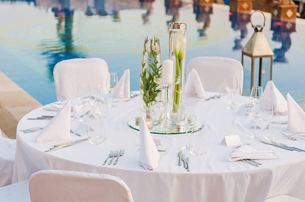Overview of elegant white wedding reception table setting Romantic wedding reception swimming pool wedding stock pictures, royalty-free photos & images
