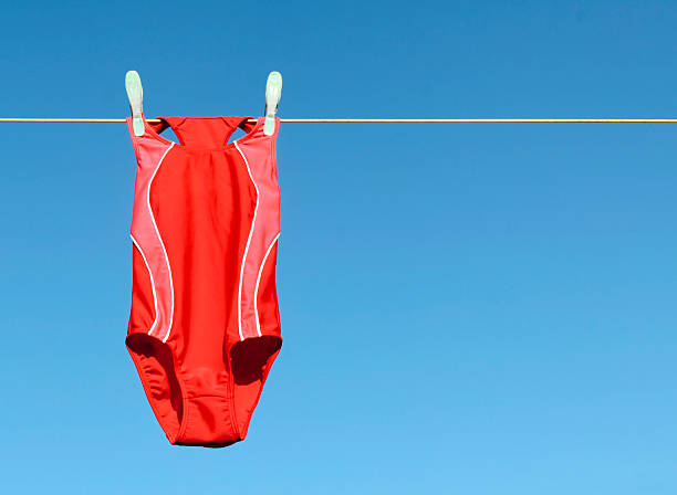 Red Swimsuit A red swimsuit hanging on a clothesline drying in the sun. one piece swimsuit photos stock pictures, royalty-free photos & images
