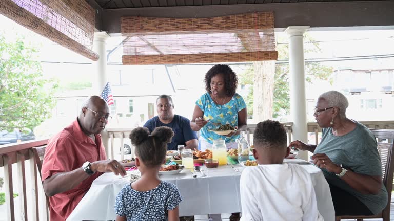 African-American family enjoying summertime meal outdoors