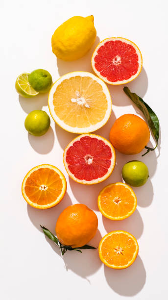 Fresh citrus fruits fool of vitamins: oranges, blood oranges (tarocco), pomelo, grapefruit lemons and lime on white background, sunlight, top view stock photo