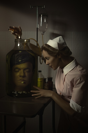 The head in the jar is actually a picture taken of the photographer, printed on paper and rolled into the glass jar, with colored water added to create this spooky effect of a head in formalin