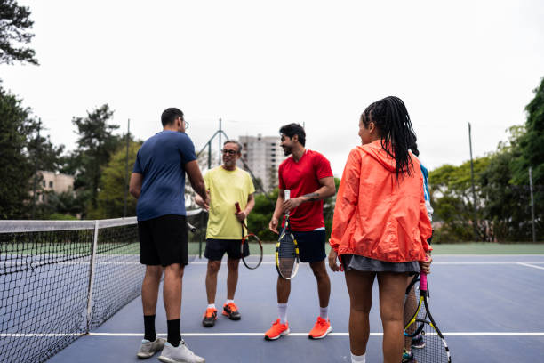 istock Coach greeting students arriving to tennis class 1759499515