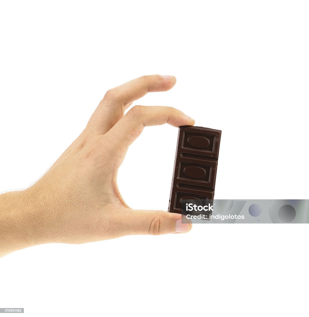 Hand holds dark chocolate bar. Hand holds dark chocolate bar. White background. Abstract Stock Photo