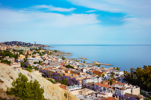 Playa or beach in Spanish Pedregalejo at Malaga suburb with many colorful houses along beachfront boulevard view form hill