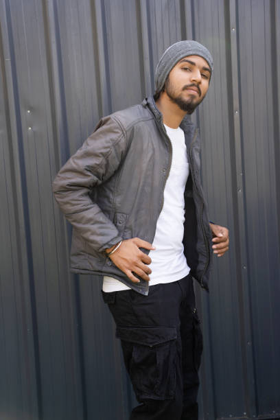 istock young indian men wearing warm winter jacket posing. Standing isolated over grey background 1759529679