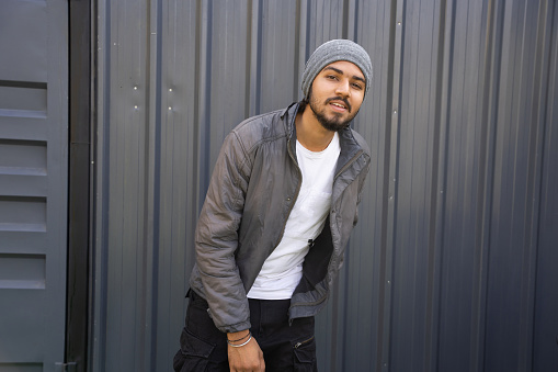 young indian men wearing warm winter clothes posing. Standing isolated over black background