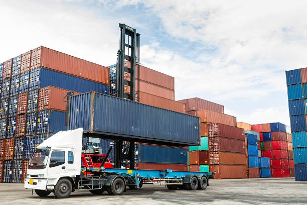 Shipping container being loaded on to a truck for delivery stock photo